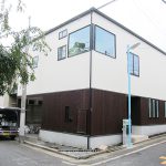 天然木を貼った1階に白い箱の2階が乗る外観の構成